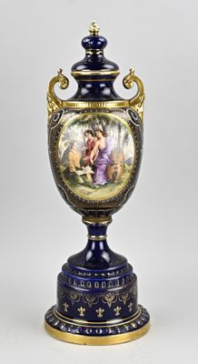un vase bleu avec une peinture dessus, posé sur une table