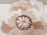 a bath mat with a flower on it on the floor