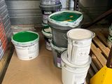 plusieurs seaux de peinture posés sur une palette dans un entrepôt