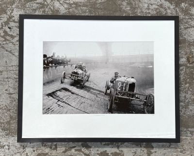 a black and white photo of two old cars on a track