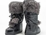 une paire de bottes noires ornées de fourrure, sur fond blanc
