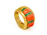 a close up of a gold ring with red and green stones