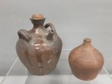 deux vases marron exposés dans une vitrine