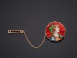 une broche en or et émail représentant le visage d'une femme