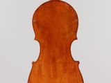 an old violin hanging from a string on a wall