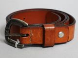 une ceinture marron avec une boucle métallique sur un fond blanc