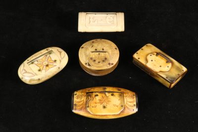 four pieces of carved ivory with designs on them sitting on a black surface