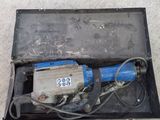 a small electric drill in a box on the floor