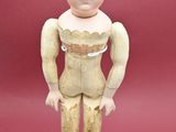 a small doll that is standing on a white pedestal