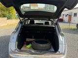 une voiture dont le coffre est ouvert et qui contient un pneu