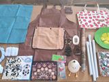 une table sur laquelle se trouvent de nombreux objets, notamment un tablier, un saladier, une assiette et d'autres objets