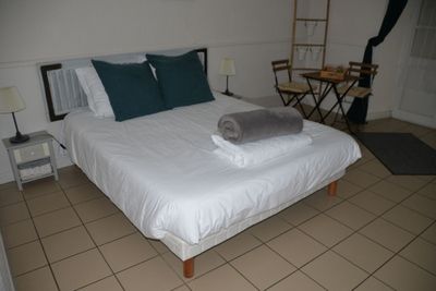 un lit avec des draps blancs et des oreillers, dans une chambre