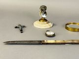 a knife, a watch, and other items that are on a table