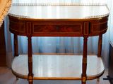 une petite table avec un plateau en marbre dans une pièce