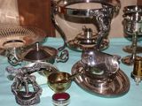 many silver objects on a table with a blue table cloth
