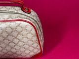 a white and red bag on a pink surface