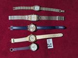 several watches are lined up on a red surface with a price tag