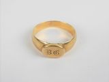 gros plan d'une bague en or sur une surface blanche