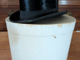 a black top hat sitting on top of a white box