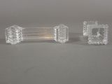 pair of clear glass candlesticks on a grey surface