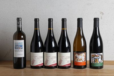 several bottles of wine are lined up on a wooden table