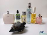 many different types of perfumes on a white table