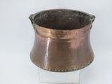 a small copper pot on a clear stand