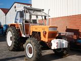 a large orange tractor parked in front of a building