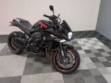 une moto noire garée sur un sol à damier