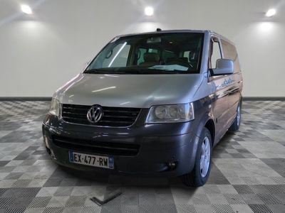 une camionnette argentée garée dans une pièce au sol carrelé en damier