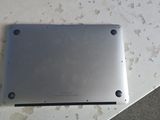 a silver tablet computer sitting on top of a white table