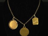 gold plated necklace with four charms on a black mannequin