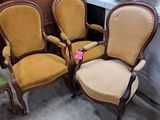 four chairs are lined up in a room with a table and a lamp