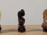 three figurines of different shapes and sizes on a wooden surface