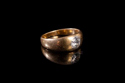 gros plan d'une bague en or avec des diamants sur une surface noire