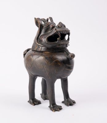 une vieille statue en bronze représentant un chien la gueule ouverte, sur fond blanc