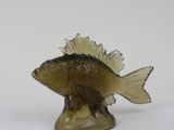 a glass fish figurine sitting on a white surface
