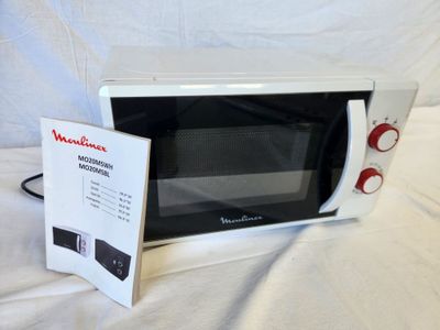 a microwave that is sitting on a bed with a menu