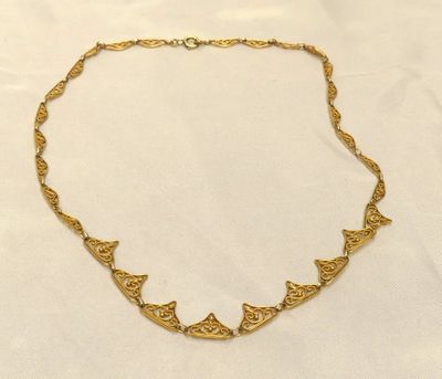 un collier en or sur fond blanc