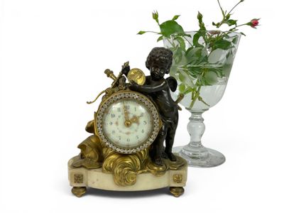 a statue of a boy holding a clock next to a vase of flowers