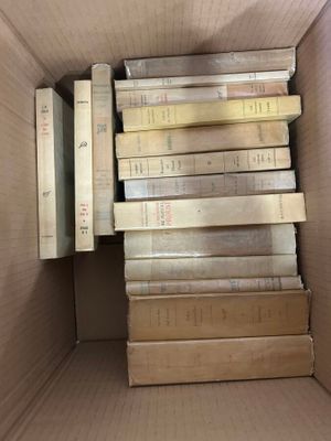 many books in a cardboard box on the floor