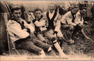 un groupe d'hommes assis sur l'herbe devant une tente