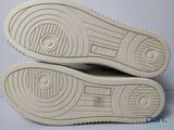 the soles of a pair of white shoes on a white surface