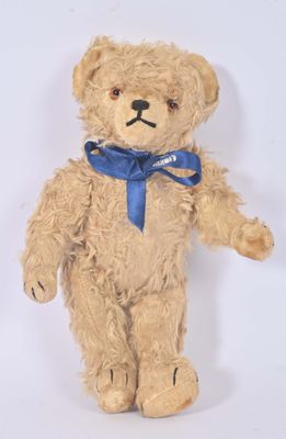 un ours en peluche marron avec un nœud bleu autour du cou