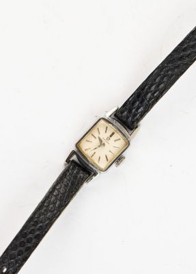 an old wrist watch with a black leather band and a gold face