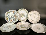 several plates are arranged on a black table with a black background