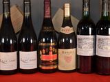 several bottles of wine are lined up on a red table