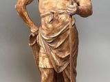 bronze statue of a man with a spear and shield on a stand