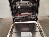 a dishwasher in the middle of a kitchen with a remote control