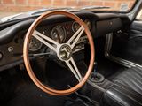 the steering wheel and dashboard of a classic car with a brick wall in the background
